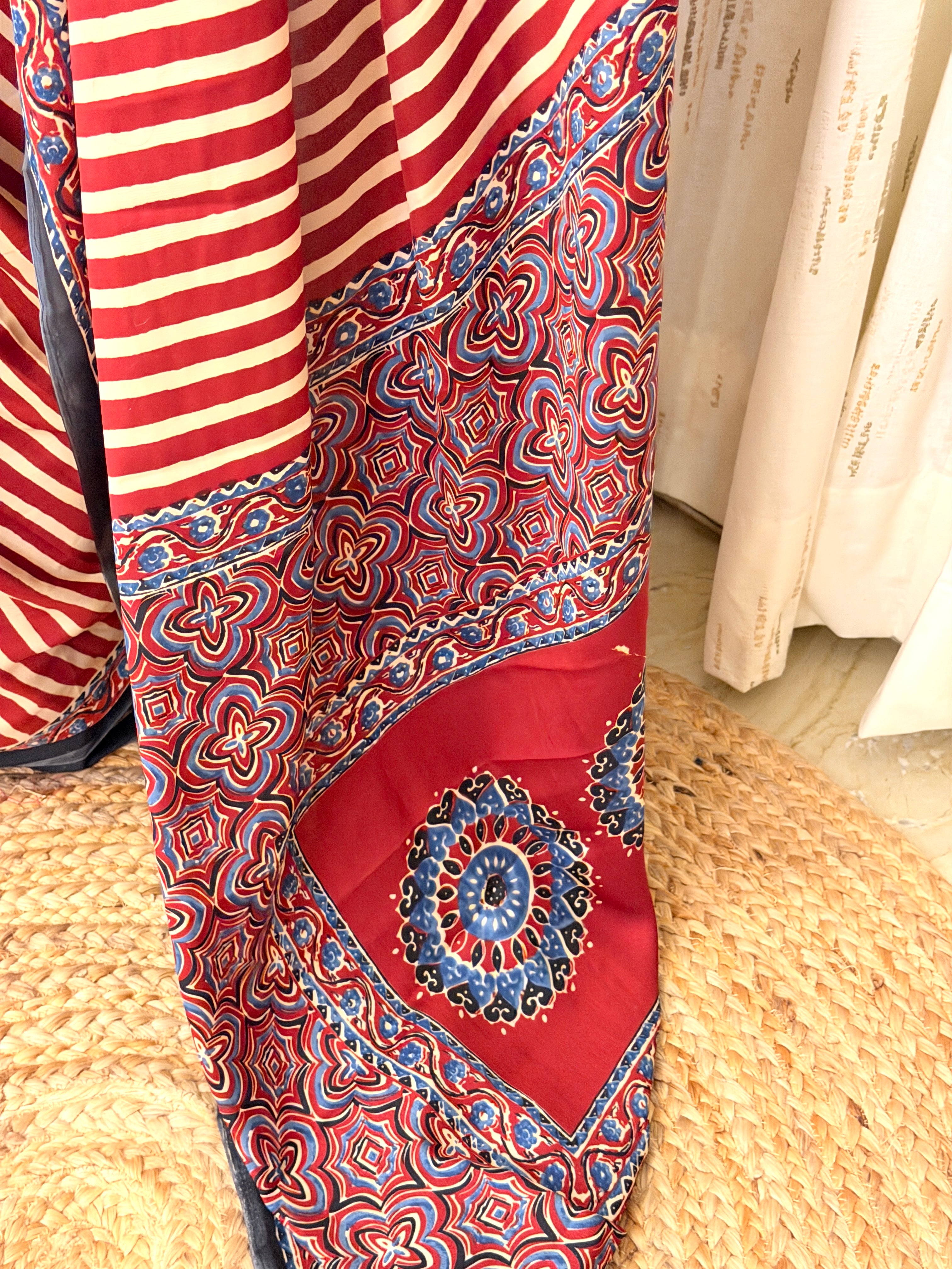 Close-up of Ajrakh floral medallion pallu in maroon, blue and black on striped saree