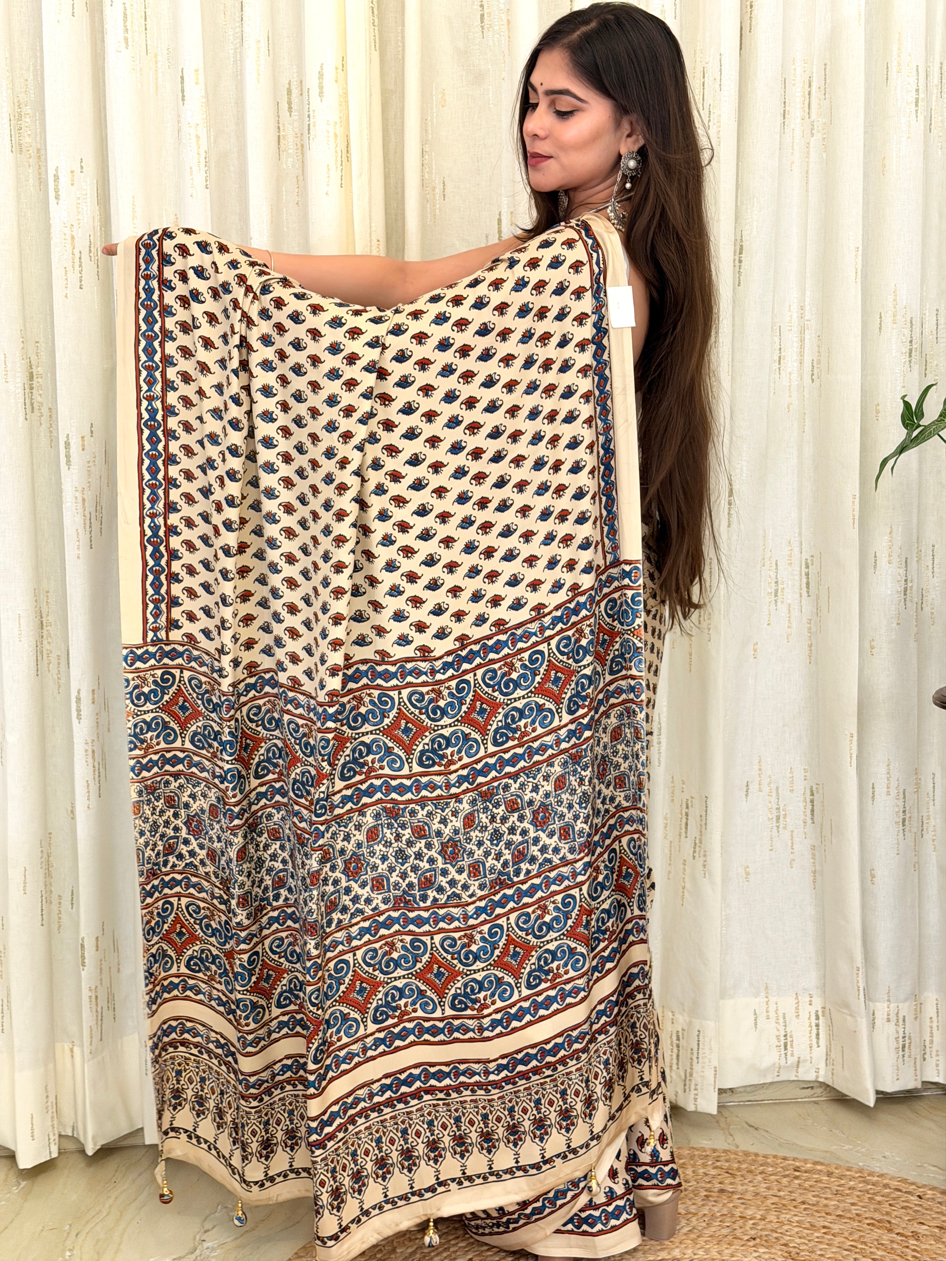 Ivory Ajrakh saree pallu held open showing scroll and diamond medallion pattern