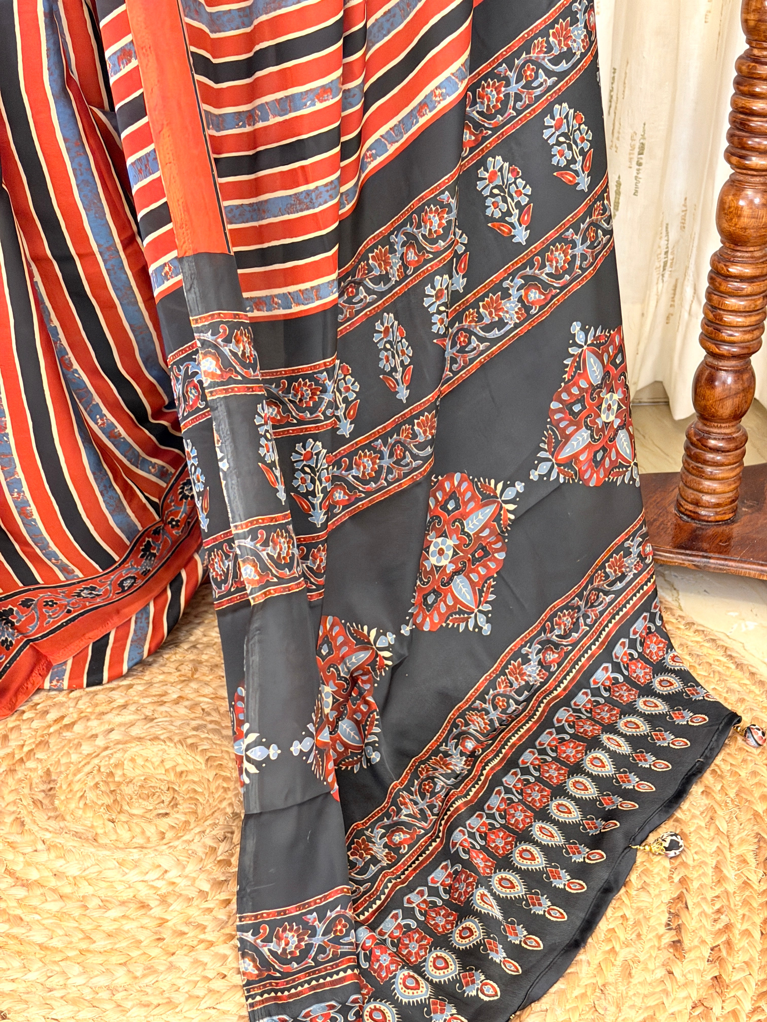 Black Ajrakh pallu with floral medallions and paisley border on rust striped saree