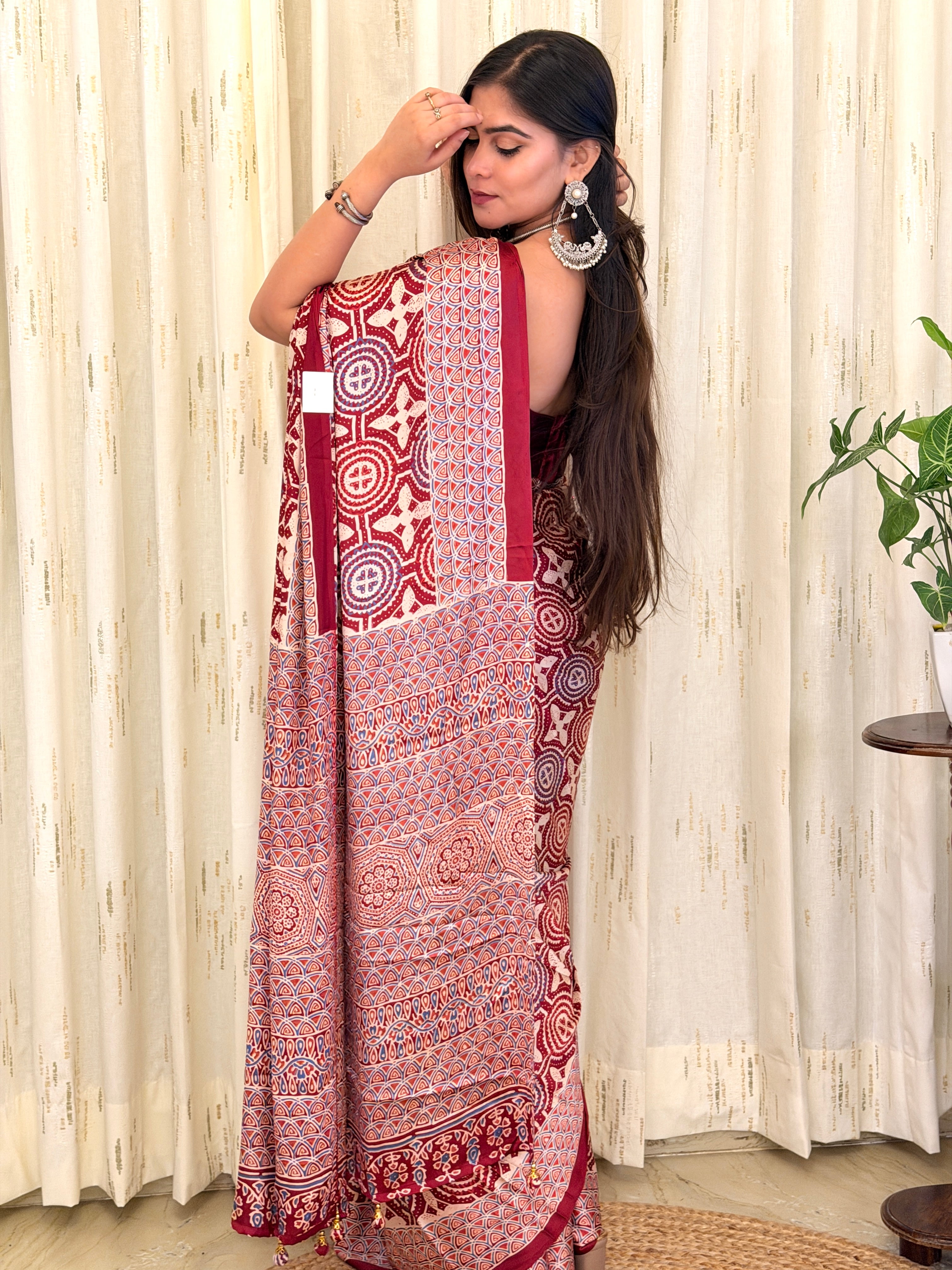 Woman in maroon Ajrakh medallion print saree - back view with open hair