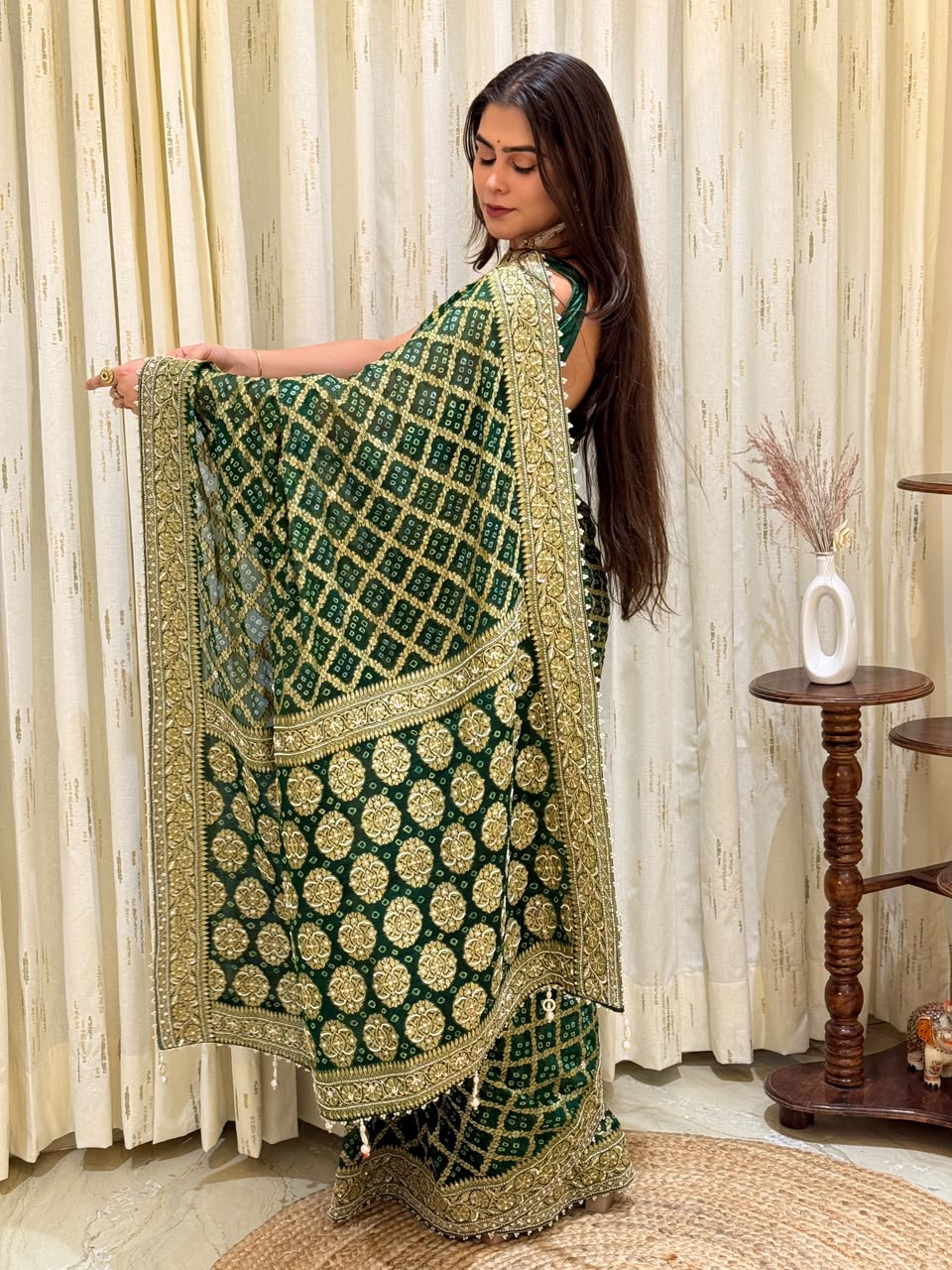"Emerald green geometric grid print saree featuring heavy gold zari floral embroidery, intricate borders, and delicate pearl-bead edging."