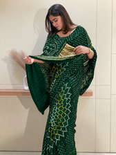 "Dark green Bandhani saree showcasing gold tissue pallu border by Pratibha Sarees."