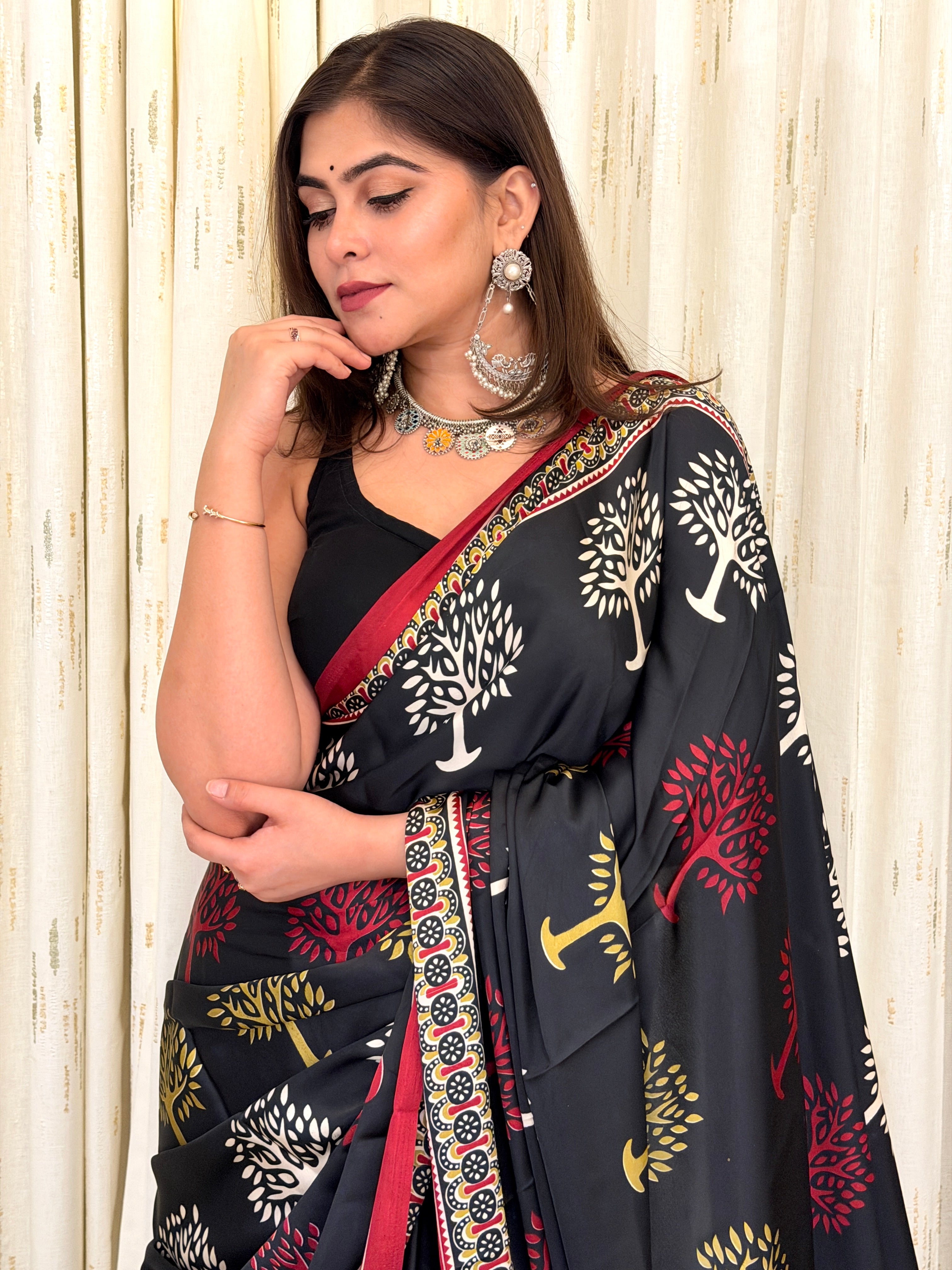 Woman in black Tree of Life print saree with silver jewellery - side profile