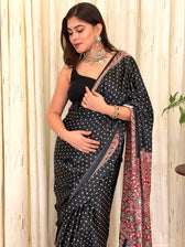 Close-up of black satin saree with bandhani dots and red Ajrakh border pallu