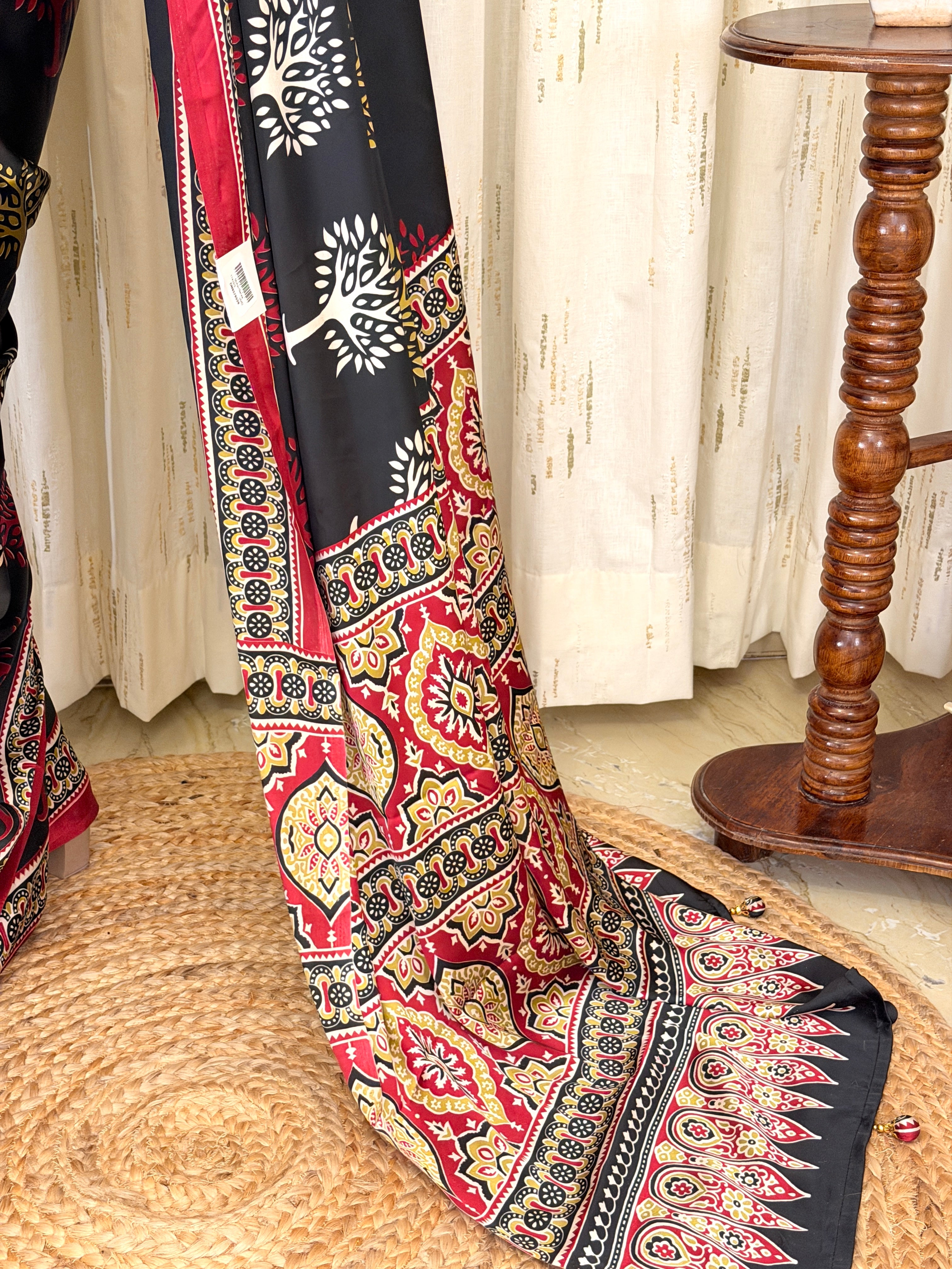 Close-up of black saree pallu showing Ajrakh medallion border with tassel detail