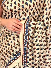 Close-up of ivory paisley print saree fabric with blue and rust border detail