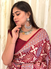 Close-up of maroon Ajrakh saree pallu border near shoulder with silver jewellery