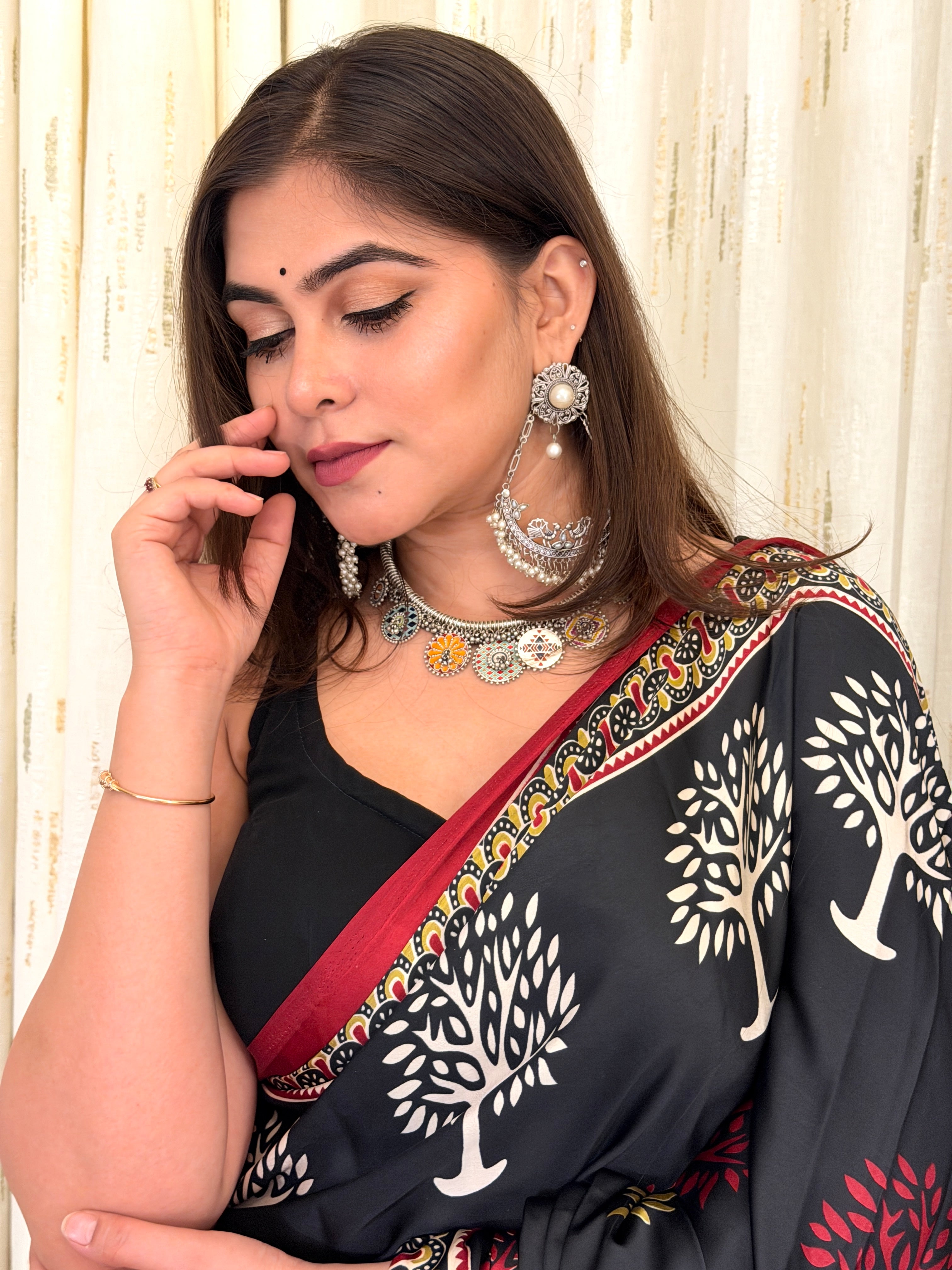 Close-up of Tree of Life motif on black modal silk saree with maroon border
