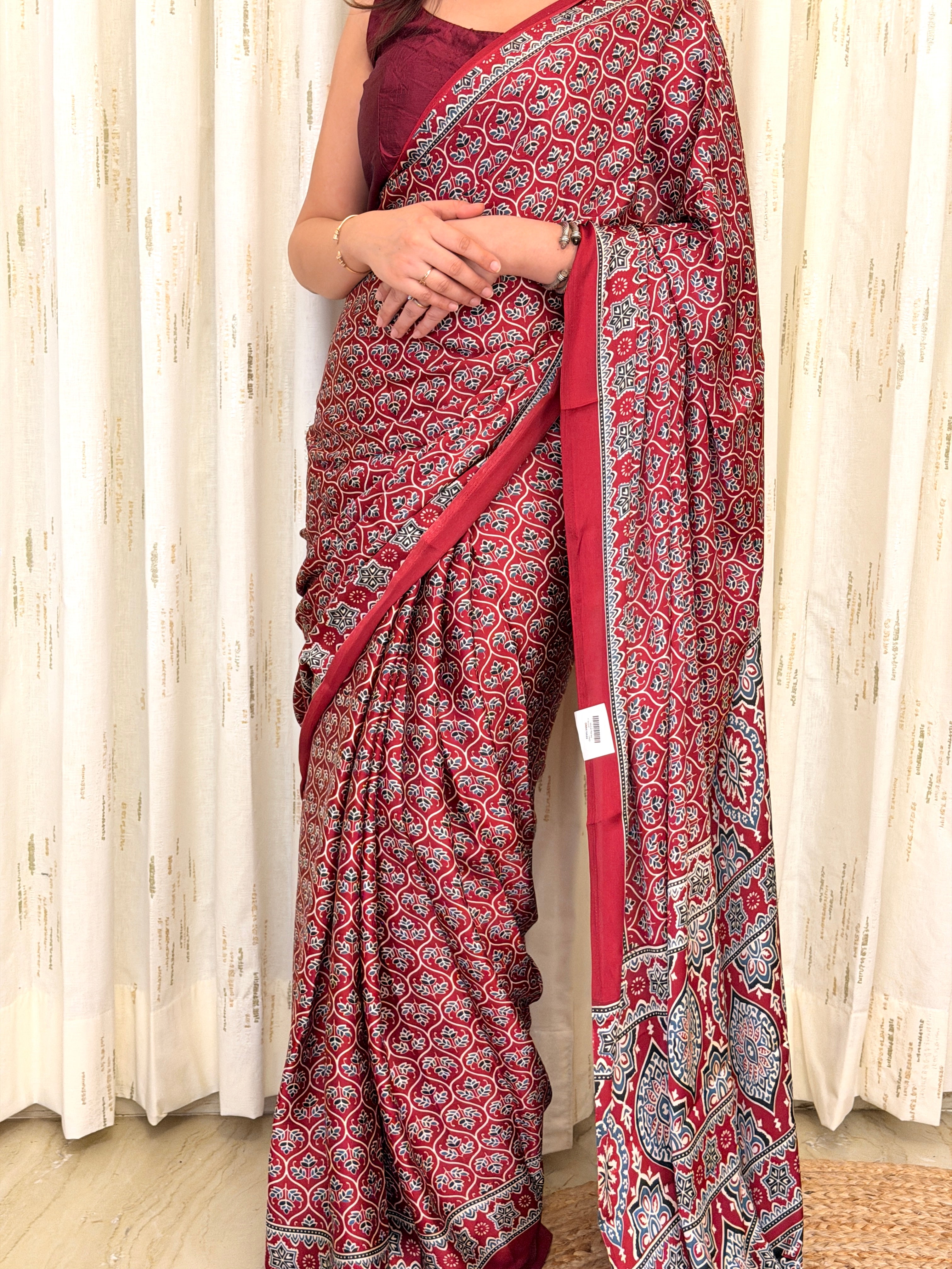 Close-up of maroon leaf-vine Ajrakh print saree fabric with border detail
