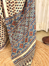 Detailed view of rust and blue Ajrakh scroll pallu border on ivory saree