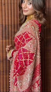 "Close-up detail of heavy gold embroidery on red Sonali Singh inspired Bandhani saree by Pratibha Sarees."