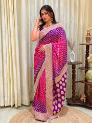 "Dual-tone purple and magenta Bandhani ombre saree featuring heavy gold zari embroidery, floral medallion motifs, and pearl-bead borders."